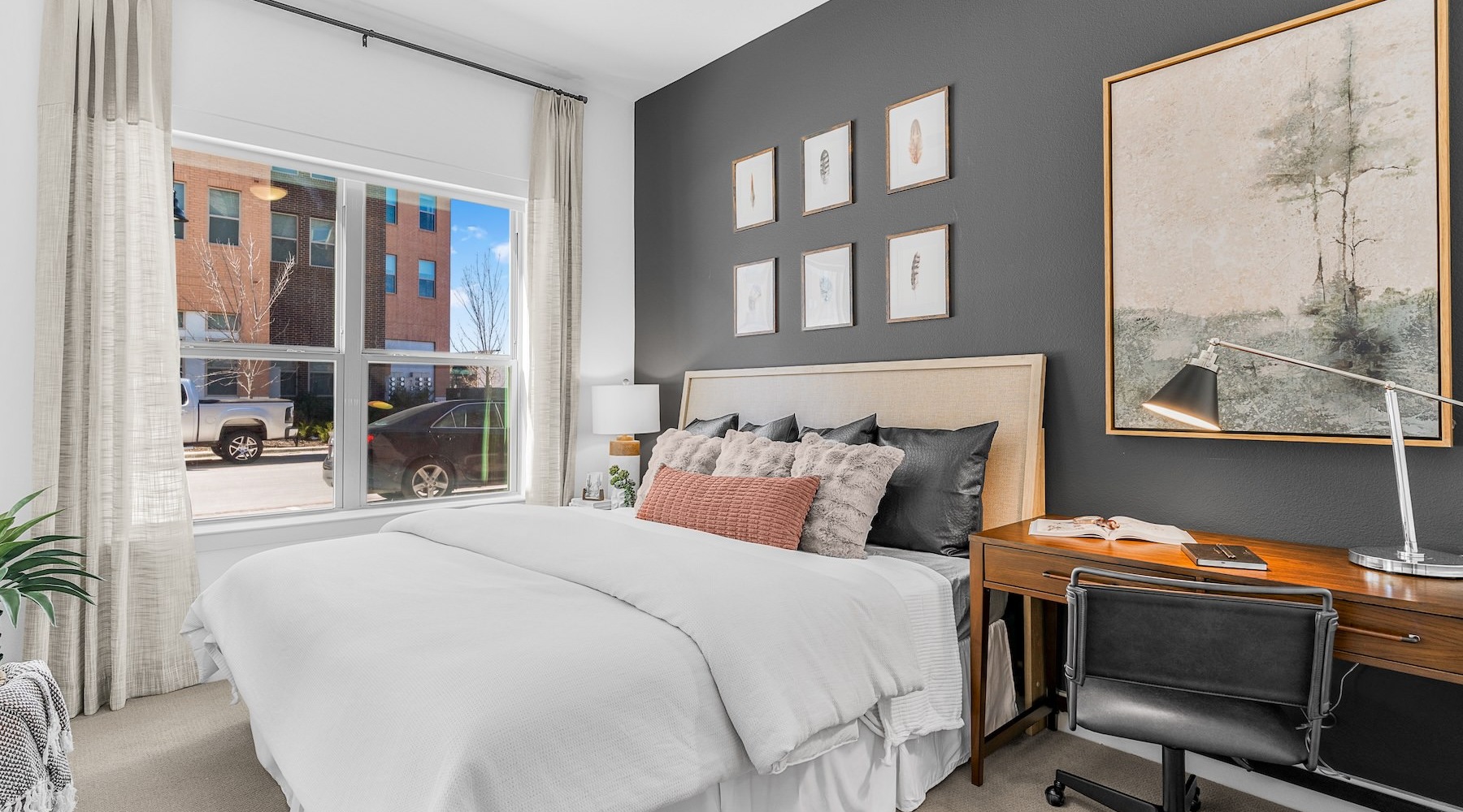 a bedroom with a bed and a desk with a chairs