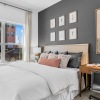 a bedroom with a bed and a desk with a chairs