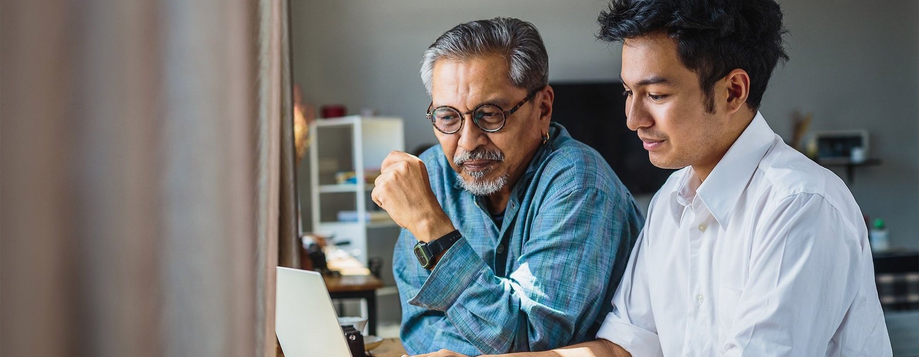two men looking at a computer